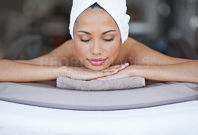 Buy stock photo Shot of a young woman lying on a massage table