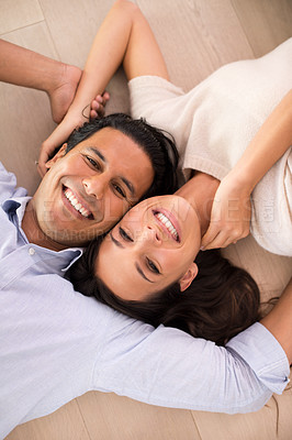 Buy stock photo Portrait, smile and top view of couple on floor, holding hands and relax together in home. Above, man and face of happy woman bonding for connection, love or support for healthy relationship in house