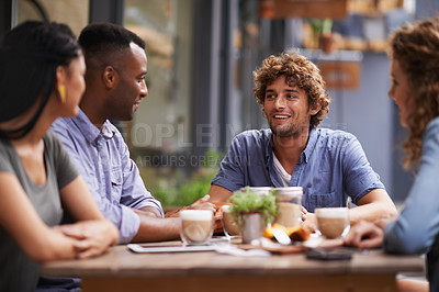 Buy stock photo A group of young friends sitting outside at a sidewalk cafe