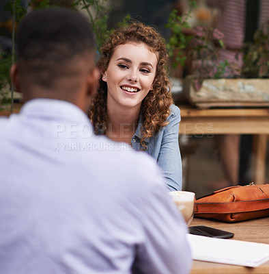 Buy stock photo Interracial couple, smile and date at restaurant, cafe and coffee shop for conversation. Happy woman, man and relax at cafeteria for communication, connection and bonding together for relationship