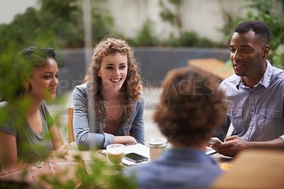 Buy stock photo A group of young friends sitting outside at a sidewalk cafe