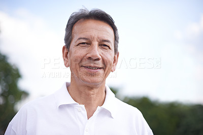 Buy stock photo Mature man, portrait and relax in outdoors, smile and cloudy sky in countryside or park. Male person, calm and fresh air for wellness on holiday or vacation, adventure and travel in nature for peace