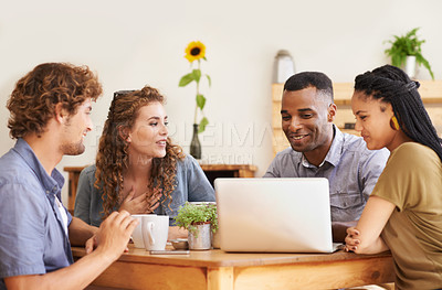 Buy stock photo A group of friends sitting together in a coffee shop with a laptop