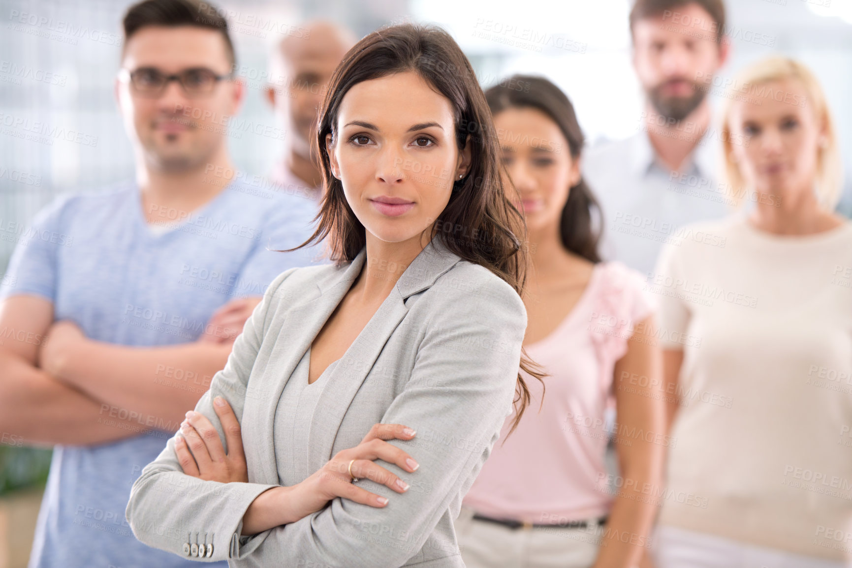 Buy stock photo Shot of a confident businesswoman standing in front of her coworkers