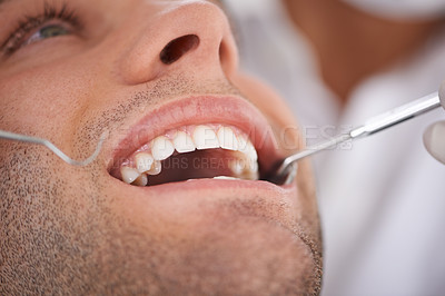 Buy stock photo Closeup shot of a young man's teeth being examined by a dentist