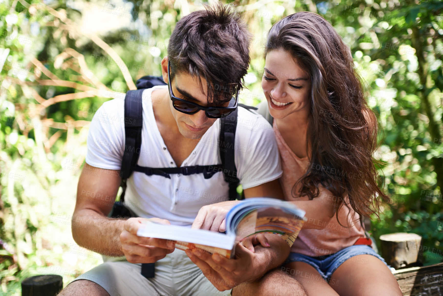 Buy stock photo Couple, map and backpack for hiking in jungle with reading for thinking, holiday or search by trees. Man, woman and bag for trekking, direction or journey in forest with book for location in Colombia