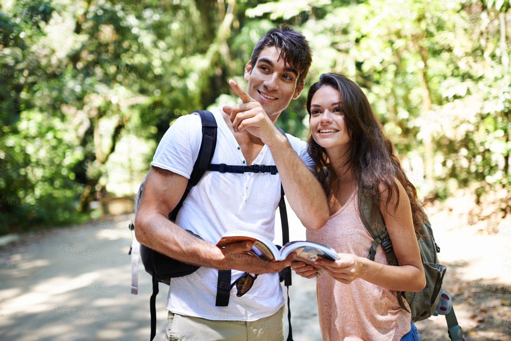 Buy stock photo Couple, map and point for hiking in forest with reading for thinking, holiday and ideas on path. Man, woman and bag for trekking, direction and search in jungle with book for location in Colombia