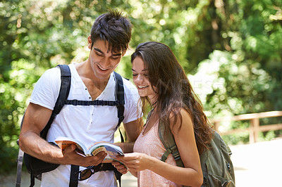 Buy stock photo Couple, map and reading for hiking in woods with smile for thinking, holiday and ideas on path. Man, woman and bag for trekking, direction and search in rainforest with book for location in Colombia