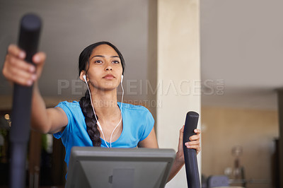Buy stock photo Shot of a young woman working out in the gym on a stepping machine