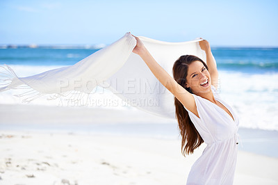 Buy stock photo A beautiful young woman on the beach holding a white scarf that's blowing in the wind