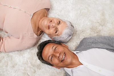 Buy stock photo Portrait, elderly or happy couple on carpet to relax in home for bonding or support together. Smile, old people or man lying down on mat by a senior woman for love, retirement or care in marriage