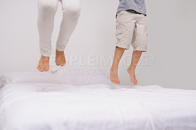 Jumping, bed and kids with legs, energy and morning in a bedroom with game and feet. Youth, sibling and home with a excited child on duvet in air with crazy play, leap and fun in house with friends