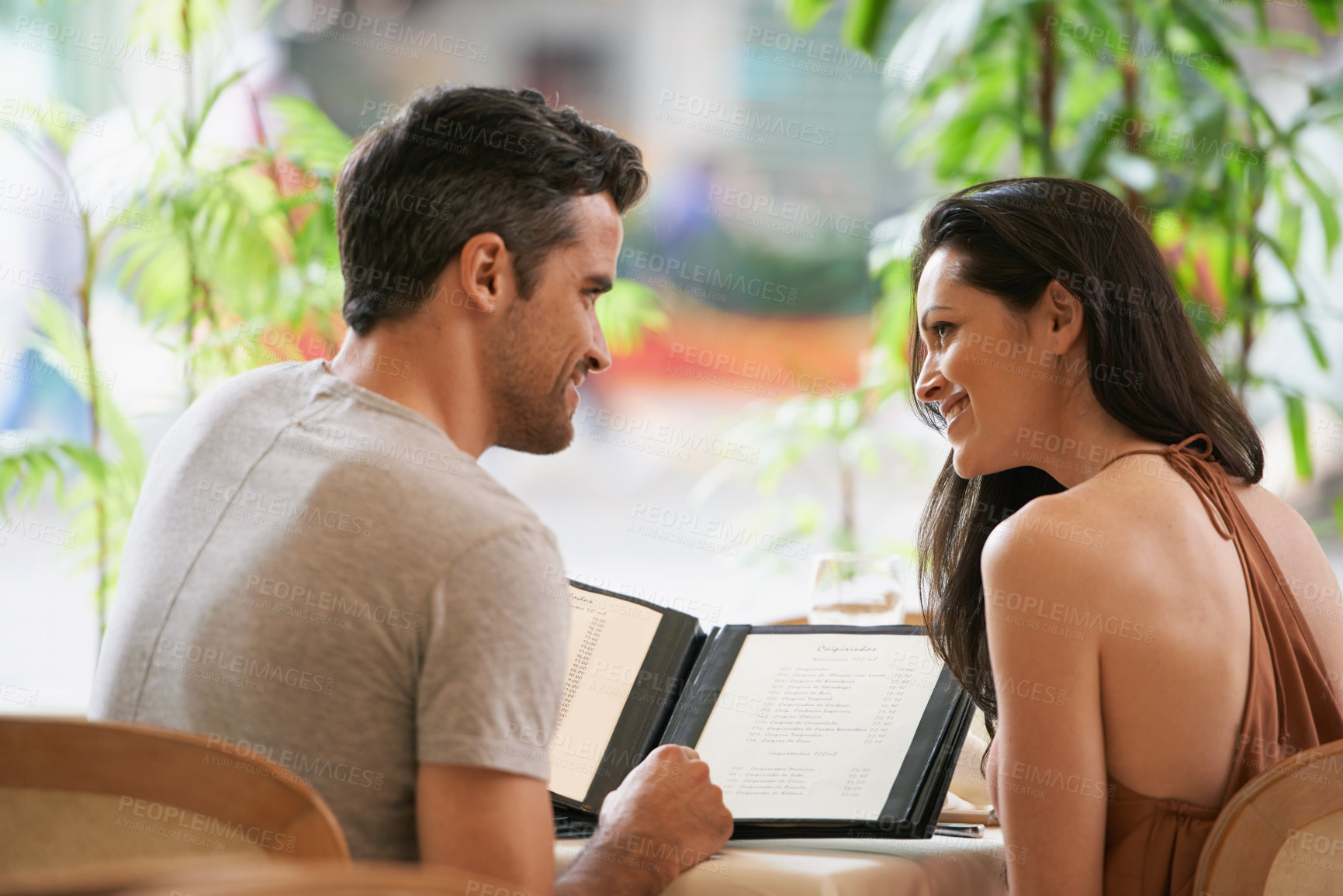 Buy stock photo Couple, restaurant and menu for conversation, selection and bonding on valentines day. People, love and romance at cafe or lunch choice for anniversary celebration, cuisine and happy at bistro