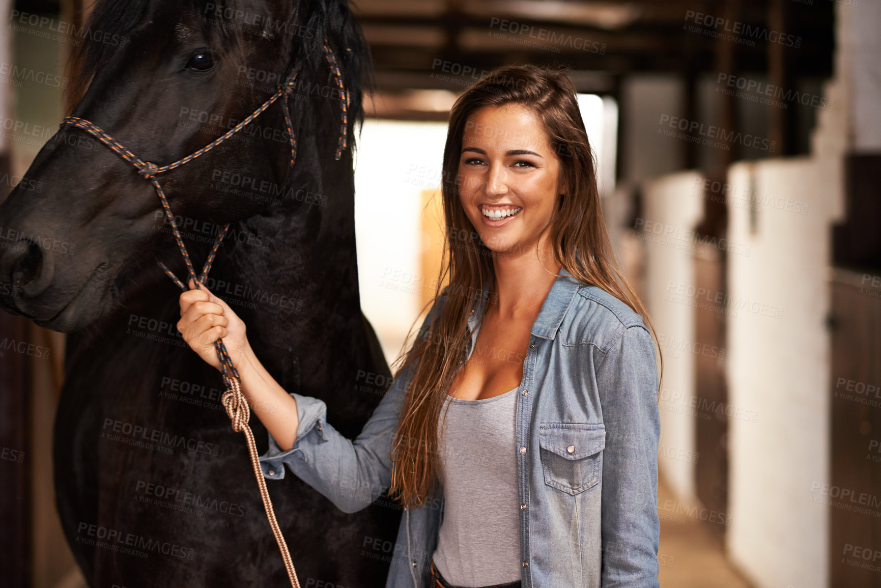 Buy stock photo Portrait of a young woman in a stable with her horse