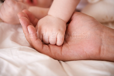 Buy stock photo Bed, holding hands and parent with infant, health and support with maternity, bonding and wellness at home. Fingers, family and love with a baby, protection and child development with bonding or care