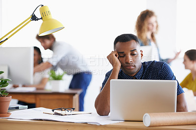 Buy stock photo An ethnic businessman looking bored and tired as he sits behind his desk