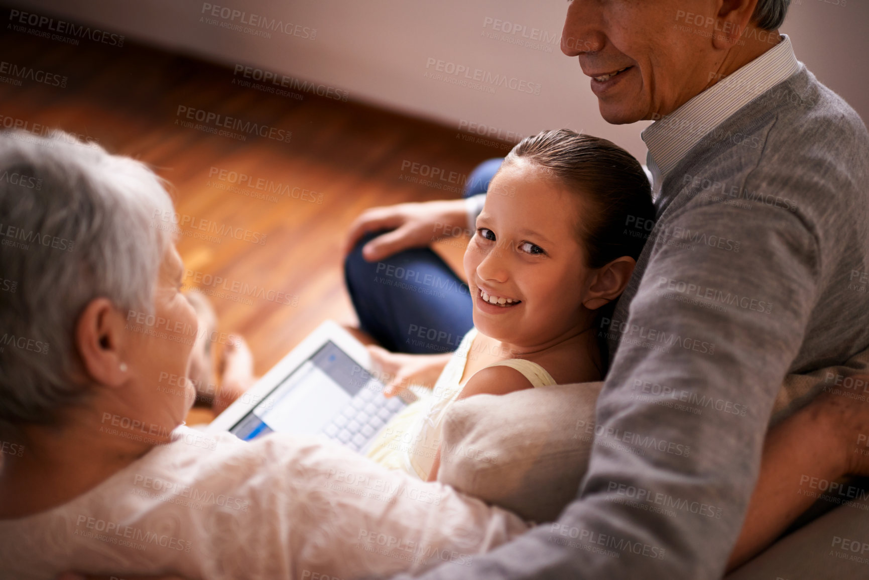 Buy stock photo Child, grandparents and tablet on couch in home or online game or communication, teaching or connection. Elderly couple, retirement and girl or internet learning in apartment, development or bonding