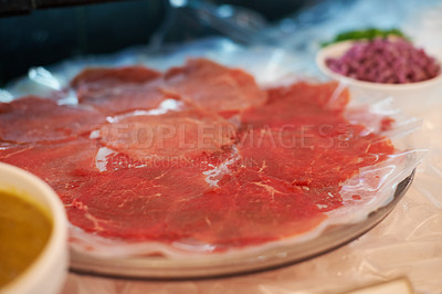Buy stock photo Carpaccio, closeup and food on plate for dinner with appetizer, fine dining and buffet of raw meat in restaurant. Beef, seafood and protein meal on table for nutrition, snack or lunch at social event