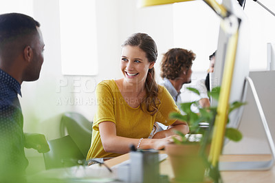 Buy stock photo Shot of a team of designers talking while working on their computers