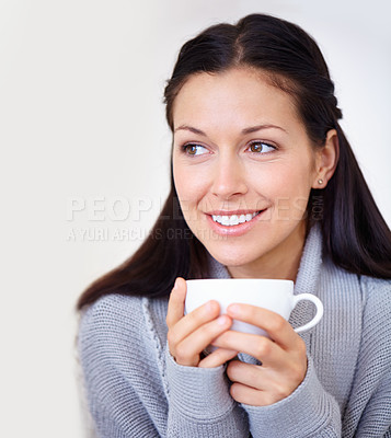 Buy stock photo Cropped shot of a beautiful young woman enjoying a cup of coffee in the morning