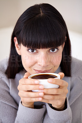 Buy stock photo Cropped shot of a beautiful young woman enjoying a cup of coffee in the morning