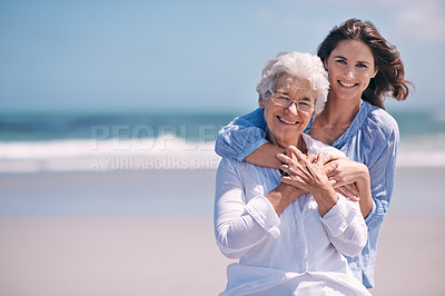 Buy stock photo Portrait, beach and young woman with her senior mother embrace and smile together outdoors on mockup. Family, happy and hugging elderly lady with adult daughter or at the ocean or sea for travel 