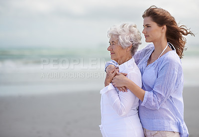 Buy stock photo Beach, young woman and her senior mother embrace or look at horizon outdoors. Mock up, free and hugging elderly woman with adult daughter or at sea or ocean thinking for affection and leisure 