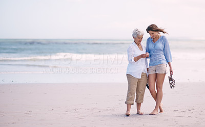 Buy stock photo Shot of a senior mother and her adult daughter exploring the beach