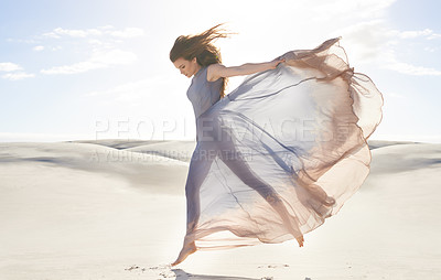 Buy stock photo Desert, woman and fashion with dress, jumping and relaxing with confidence and getaway trip. Person, outdoor and sand with girl and clouds with fabric, fun and summer with weekend break and active