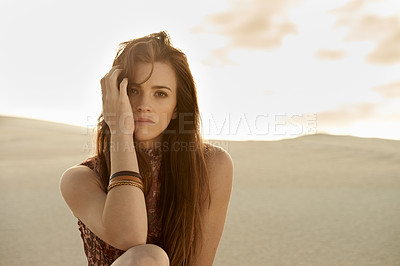 Buy stock photo Shot of a beautiful young fashion model sitting in the sand