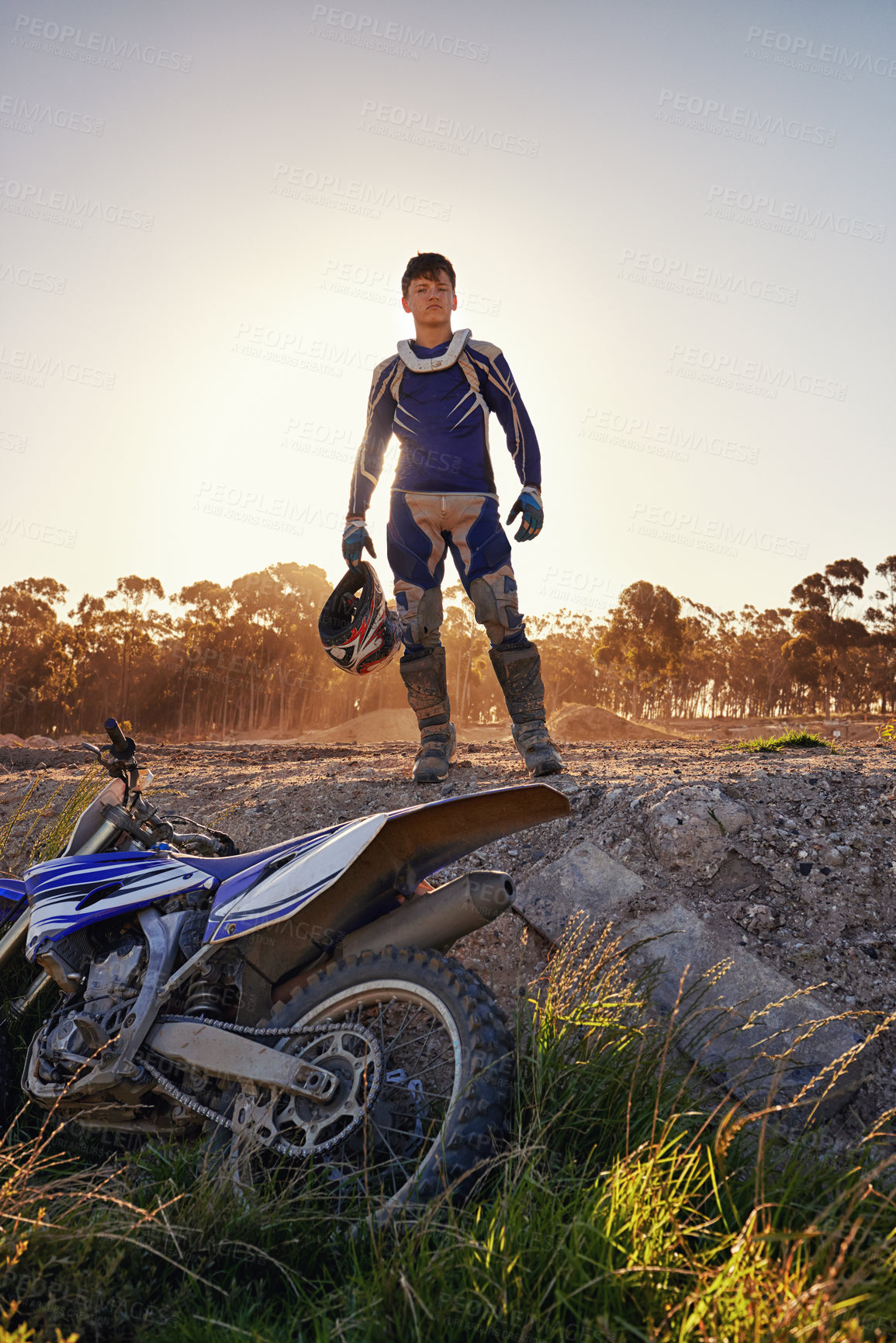 Buy stock photo Portrait, motocross and rider by dirtbike in forest, confident and extreme sport for adventure with speed. Man, pride or gear for motorcycle racing on track, sunset or skill in driving a fast vehicle