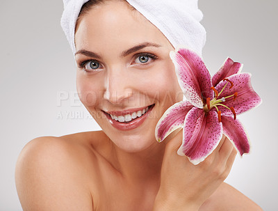 Buy stock photo Beauty, portrait and woman with towel, flower and spa treatment with cosmetics in studio. Dermatology, healthy skin and girl on white background with luxury salon facial, morning and natural skincare