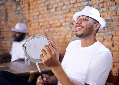 Buy stock photo Band, drums or carnival with a happy man playing an instrument in a festival in Rio de Janeiro. Brazil, smile or party with a male musician, performer or artist banging with sticks to create a beat