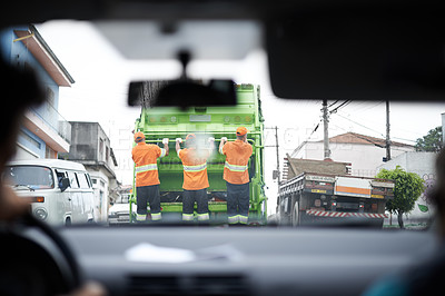 Buy stock photo Cropped rear view shot of a garbage collection team at work