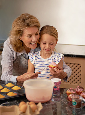 Buy stock photo Grandmother, child and baking cupcake in kitchen or helping with decoration or creative icing, sprinkles or teamwork. Female person, girl and youth learning at home or ingredients, recipe or dessert
