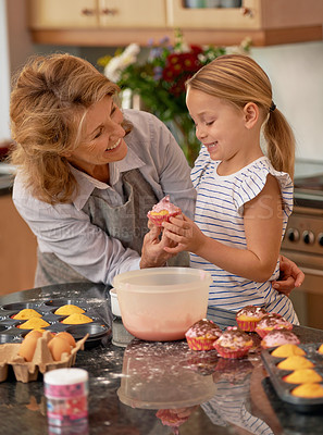 Buy stock photo Grandmother, child and cupcake decorating in kitchen with icing or sprinkles or creativity, bonding or teamwork. Female person, girl and sweet treats or teaching with dessert ingredient, snack or fun