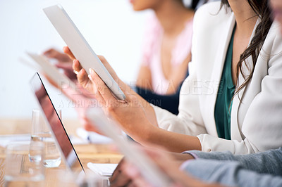 Buy stock photo Cropped shot of a group of businesspeople using their wireless devices during a meeting