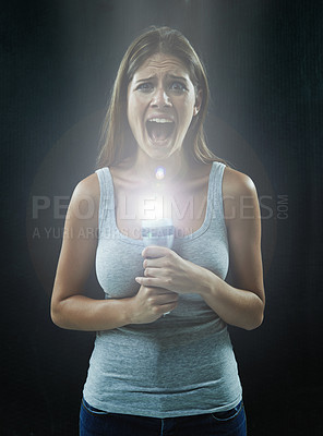 Buy stock photo Woman, portrait and scared or flashlight for scream in studio, anxiety and stress for risk in mystery. Female person, shout and lamp in dark against black background, caution and danger or horror