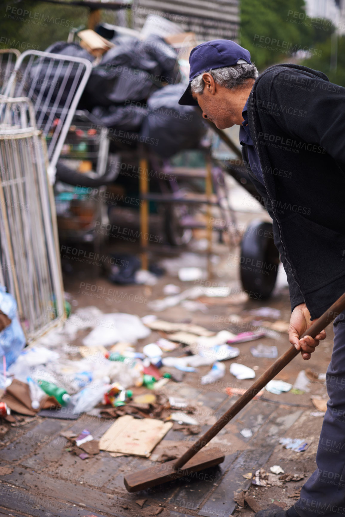 Buy stock photo Cropped shot of a street cleaner sweeping up garbage