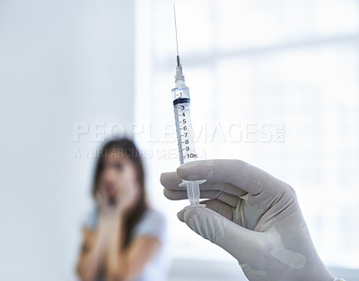 Buy stock photo A doctor preparing to give a nervous young woman an injection