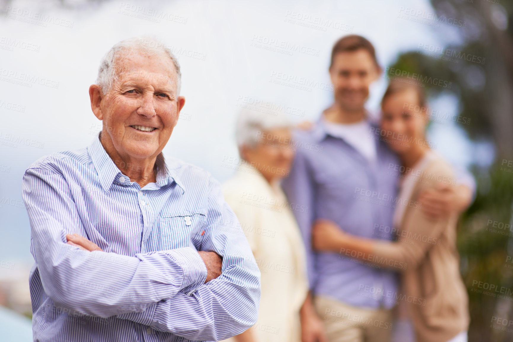 Buy stock photo Portrait of a smiling mature man with his family in the background