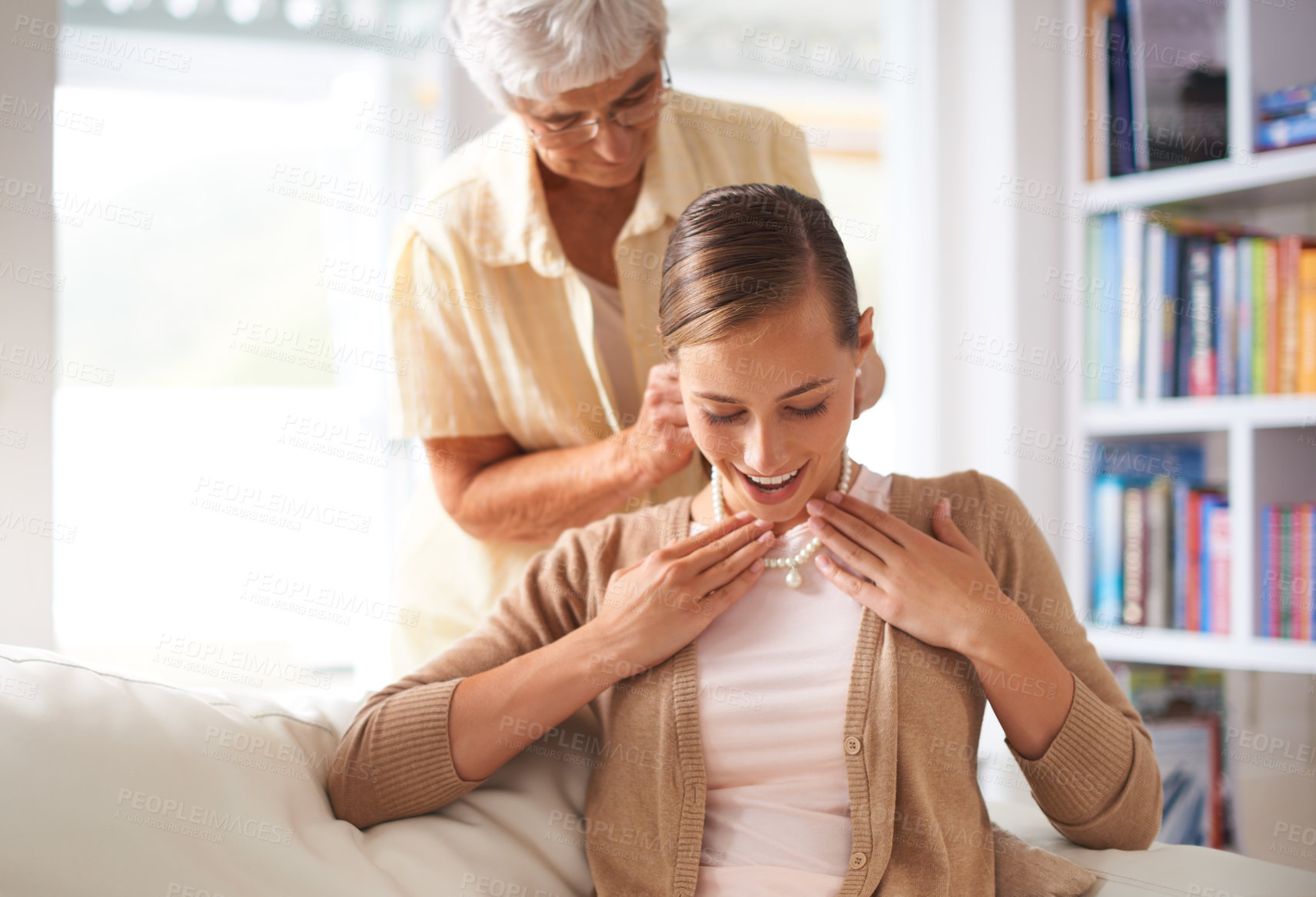 Buy stock photo Sofa, necklace and elderly mother with woman for present, gift and surprise in living room home. Family heirloom, pearls and daughter with mom with jewellery for celebration, birthday and bonding