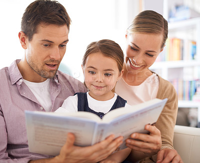 Buy stock photo Parents, kid and reading in house, sofa and child development in home schooling and bonding. Mom, dad and toddler on couch, living room and smile while learning in book and fairytale stories together