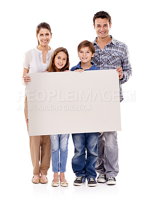Buy stock photo Studio shot of a happy family standing with a blank placard for copyspace