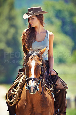 Buy stock photo Shot of a beautiful young woman riding a horse