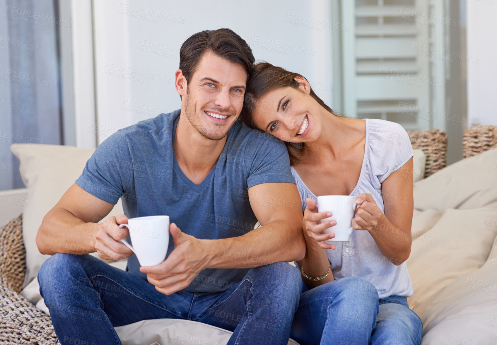 Buy stock photo Happy couple, coffee and sofa with love for morning, bonding or weekend together at home. Face of young man and woman with smile, cup of tea or cappuccino for support, care or trust at apartment