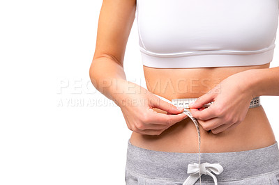Buy stock photo Closeup of a fit woman's waist while she is measuring it with tape