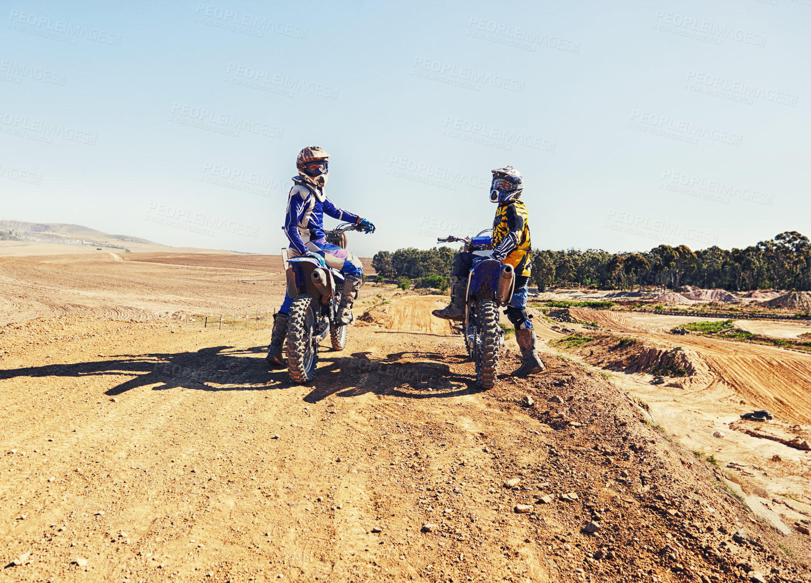 Buy stock photo Sport, racer or relax on motorcycle outdoor on dirt road with blue sky for driving, challenge or competition. Gear, motorbike or dirtbike driver with helmet on offroad course or path for racing
