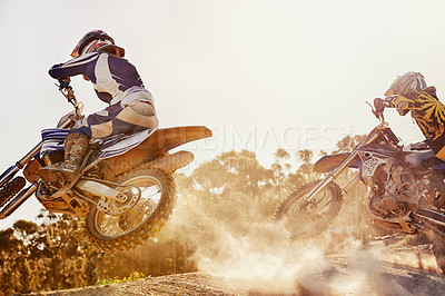 Buy stock photo A shot of two dirtbike racers going head-to-head on the track