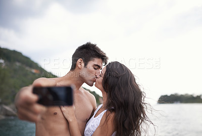 Buy stock photo Kiss, selfie and couple at ocean for vacation, holiday or travel together outdoor. Photography, woman and man at sea for love, adventure and taking pictures for memory in summer by water in nature